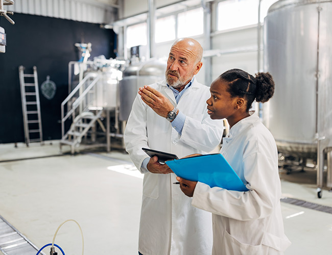 Two dairy workers discussing lab results